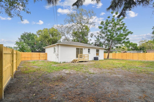 1801 E Navajo Ave, Tampa, FL 33612 - rear view of house with central air condition unit, a fenced backyard, and a deck