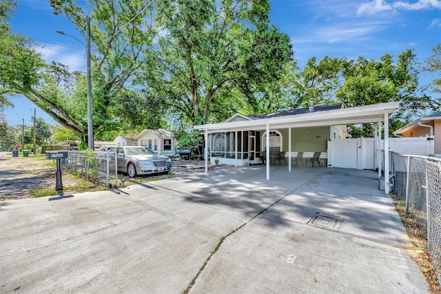 1505 E 99th Ave, Tampa, FL 33612 - view of front facade featuring a sunroom, fence, concrete driveway, and a gate