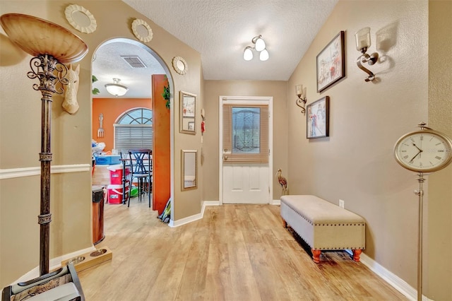 1505 E 99th Ave, Tampa, FL 33612 - entrance foyer featuring light wood-type flooring, arched walkways, a textured ceiling, and baseboards