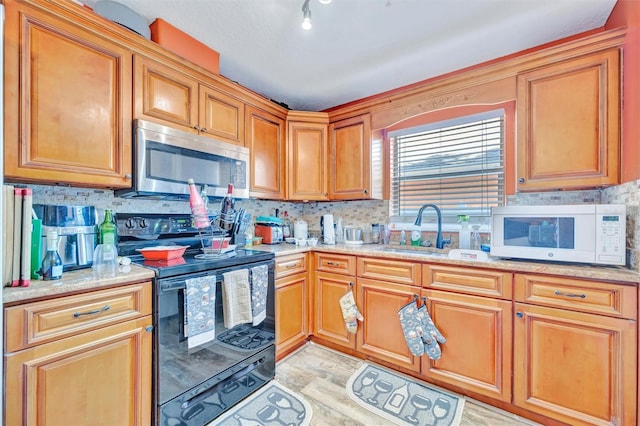 1505 E 99th Ave, Tampa, FL 33612 - kitchen with white microwave, stainless steel microwave, black electric range oven, a sink, and backsplash
