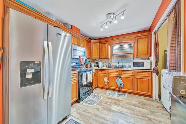 1505 E 99th Ave, Tampa, FL 33612 - kitchen featuring stainless steel appliances, a sink, light wood finished floors, light countertops, and brown cabinetry