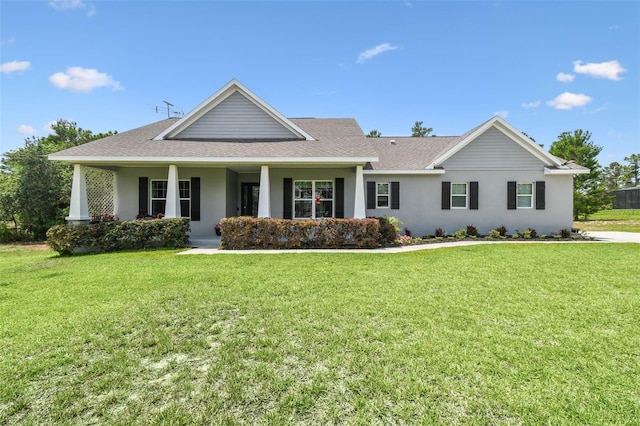 view of front of property featuring a shingled roof, a front yard, a porch, and stucco siding