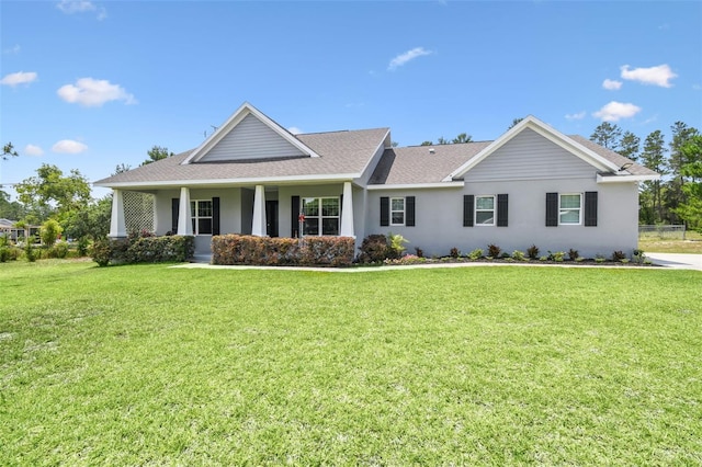 view of front facade featuring a front yard, stucco siding, and a shingled roof