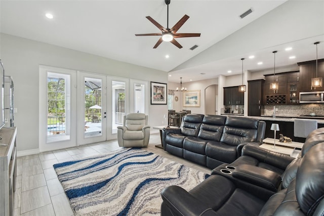 living area featuring vaulted ceiling, a ceiling fan, french doors, recessed lighting, and a chandelier