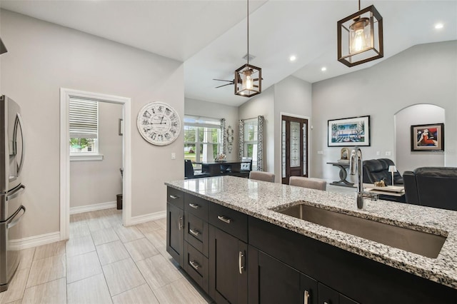 kitchen featuring a sink, open floor plan, baseboards, pendant lighting, and recessed lighting