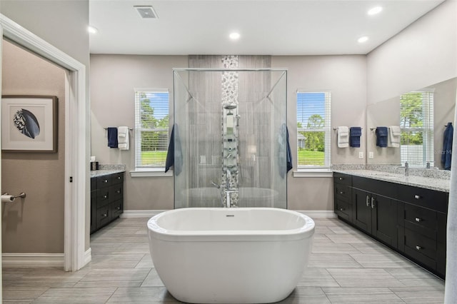full bathroom featuring vanity, a shower stall, baseboards, and recessed lighting