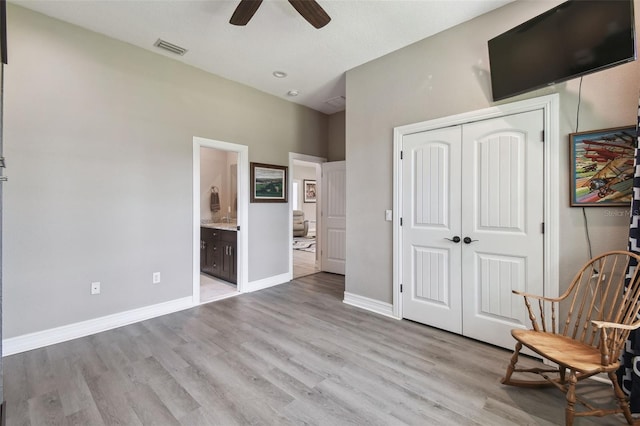 living area featuring a ceiling fan, light wood-type flooring, and baseboards