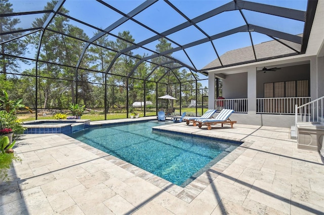 view of pool featuring a patio, ceiling fan, a pool with connected hot tub, and glass enclosure