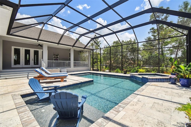 view of swimming pool featuring french doors, a patio, a pool with connected hot tub, a ceiling fan, and glass enclosure
