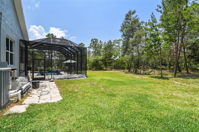 view of grassy yard with an outdoor pool, a patio, and a lanai