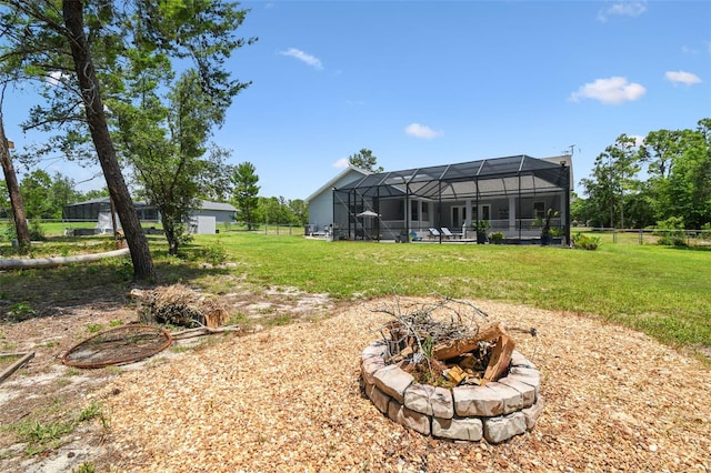 view of yard featuring glass enclosure and an outdoor fire pit