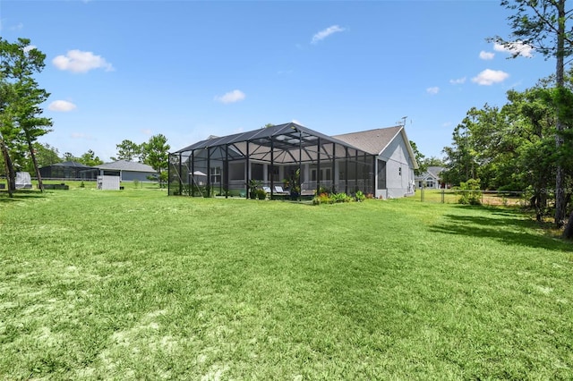 view of green lawn featuring glass enclosure