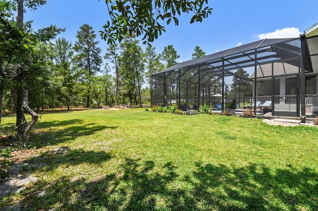 view of grassy yard featuring glass enclosure
