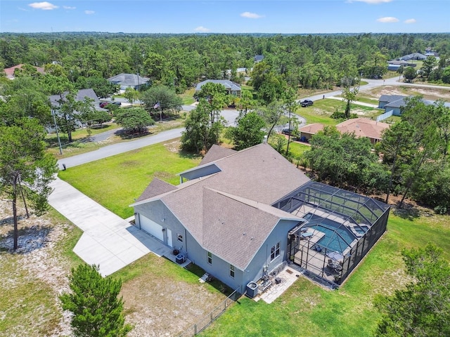 aerial view of property and surrounding area with a heavily wooded area