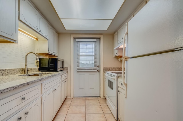 1221 Drew St Unit E12, Clearwater, FL 33755 - kitchen featuring white appliances, a sink, light tile patterned floors, under cabinet range hood, and decorative backsplash