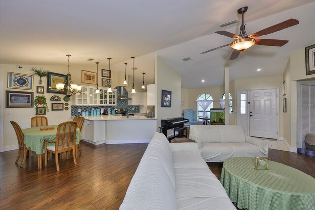 22115 Laver Ln, Land O Lakes, FL 34639 - living room featuring vaulted ceiling, a chandelier, ceiling fan, dark wood finished floors, and baseboards