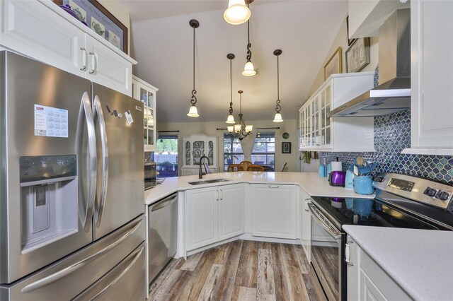 22115 Laver Ln, Land O Lakes, FL 34639 - kitchen featuring appliances with stainless steel finishes, a sink, wall chimney exhaust hood, a chandelier, and light countertops