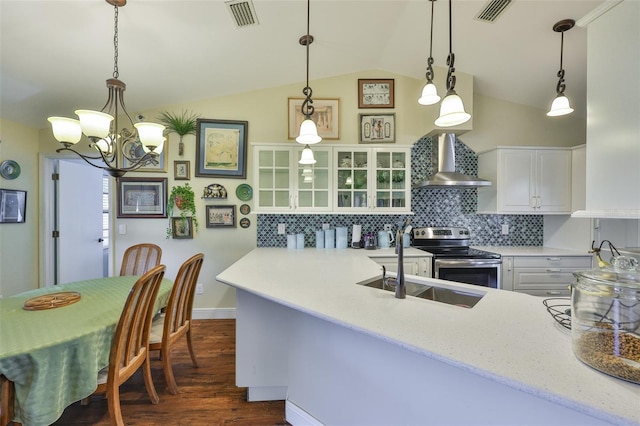 22115 Laver Ln, Land O Lakes, FL 34639 - kitchen with wall chimney range hood, stainless steel electric range oven, a chandelier, white cabinetry, and lofted ceiling