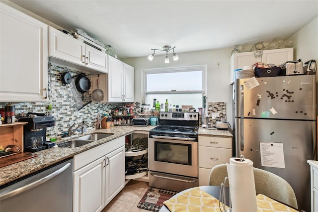 361 Colonial Ct, Dunedin, FL 34698 - kitchen featuring stainless steel appliances, a sink, white cabinets, tasteful backsplash, and light tile patterned flooring