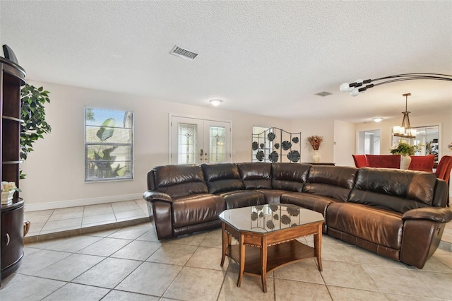 854 Village Way, Palm Harbor, FL 34683 - living room featuring light tile patterned flooring, a chandelier, a textured ceiling, and baseboards