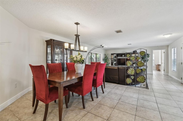 854 Village Way, Palm Harbor, FL 34683 - dining space featuring a chandelier, a textured ceiling, light tile patterned floors, and baseboards