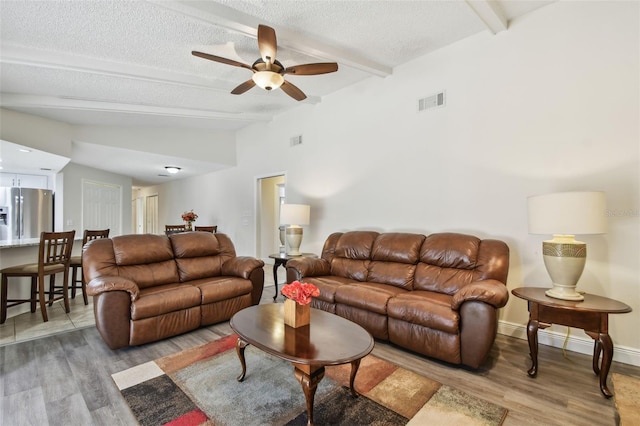 854 Village Way, Palm Harbor, FL 34683 - living area with light wood finished floors, ceiling fan, a textured ceiling, and baseboards