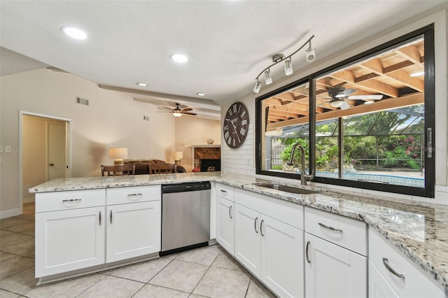 854 Village Way, Palm Harbor, FL 34683 - kitchen with stainless steel dishwasher, a ceiling fan, a sink, a fireplace, and light tile patterned flooring
