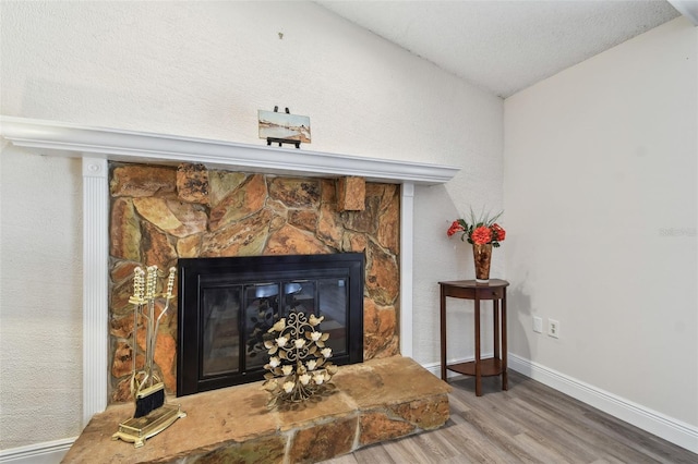 854 Village Way, Palm Harbor, FL 34683 - detailed view of wood finished floors, a stone fireplace, baseboards, and a textured ceiling