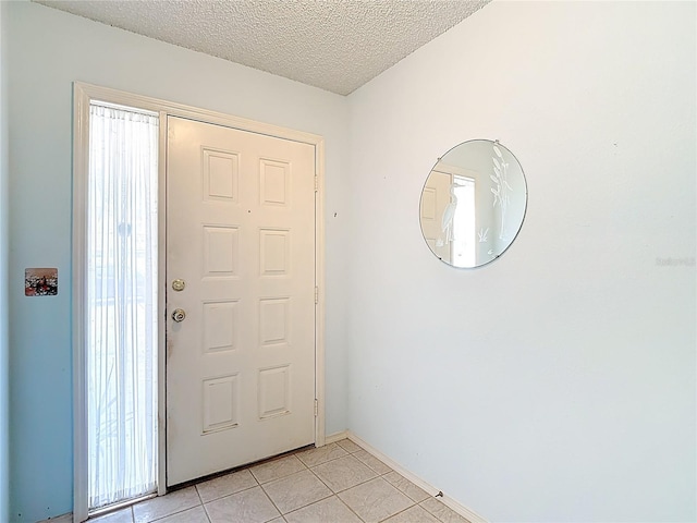 120 Colony S Dr, Tarpon Springs, FL 34689 - entryway featuring light tile patterned floors, a textured ceiling, and baseboards