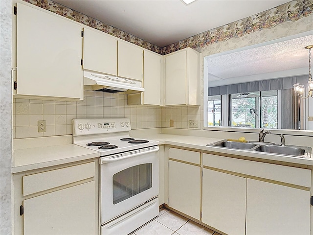 120 Colony S Dr, Tarpon Springs, FL 34689 - kitchen featuring electric stove, under cabinet range hood, a sink, light countertops, and decorative backsplash