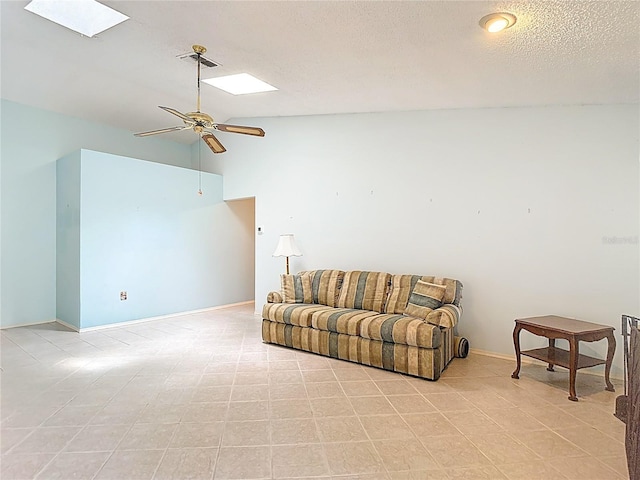 120 Colony S Dr, Tarpon Springs, FL 34689 - living room featuring a ceiling fan, a skylight, lofted ceiling, baseboards, and a textured ceiling