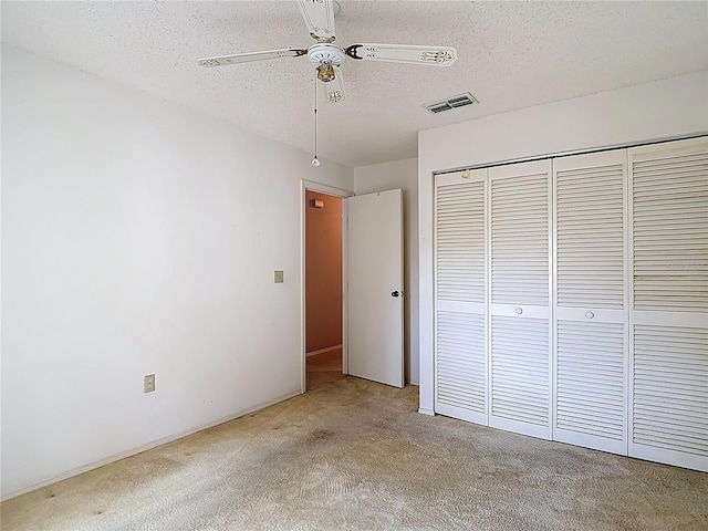 120 Colony S Dr, Tarpon Springs, FL 34689 - unfurnished bedroom featuring carpet floors, a closet, a textured ceiling, and ceiling fan