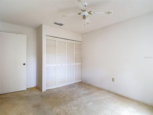 120 Colony S Dr, Tarpon Springs, FL 34689 - unfurnished bedroom featuring carpet flooring, a closet, a textured ceiling, and a ceiling fan