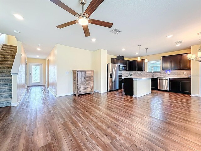 9324 Rally Spring Loop, Wesley Chapel, FL 33545 - unfurnished living room featuring ceiling fan, wood finished floors, stairway, baseboards, and recessed lighting