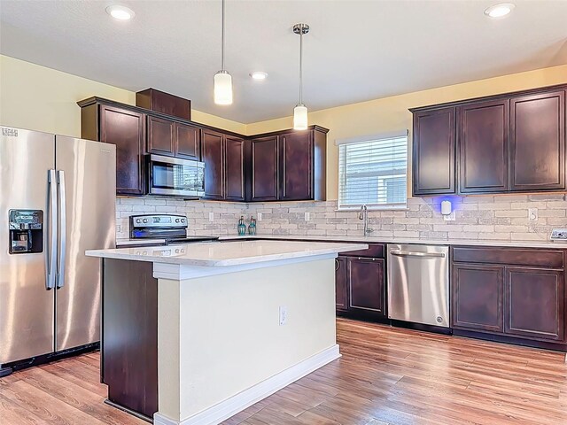 9324 Rally Spring Loop, Wesley Chapel, FL 33545 - kitchen featuring stainless steel appliances, light countertops, light wood-style floors, dark brown cabinetry, and backsplash