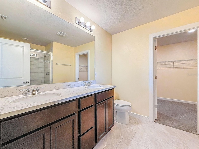 9324 Rally Spring Loop, Wesley Chapel, FL 33545 - bathroom featuring a stall shower, toilet, a textured ceiling, double vanity, and baseboards