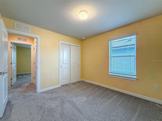 9324 Rally Spring Loop, Wesley Chapel, FL 33545 - unfurnished bedroom with carpet, a textured ceiling, baseboards, and a closet