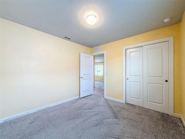 9324 Rally Spring Loop, Wesley Chapel, FL 33545 - unfurnished bedroom with carpet flooring, baseboards, a textured ceiling, and a closet