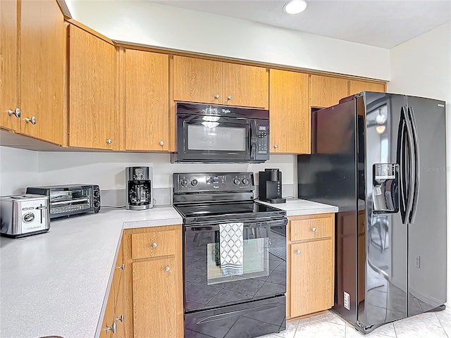 11122 W Cove Harbor Dr Unit 112, Crystal River, FL 34428 - kitchen with black appliances, light countertops, brown cabinetry, and light tile patterned flooring