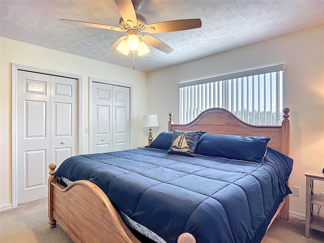 11122 W Cove Harbor Dr Unit 112, Crystal River, FL 34428 - bedroom with light colored carpet, two closets, a textured ceiling, baseboards, and ceiling fan