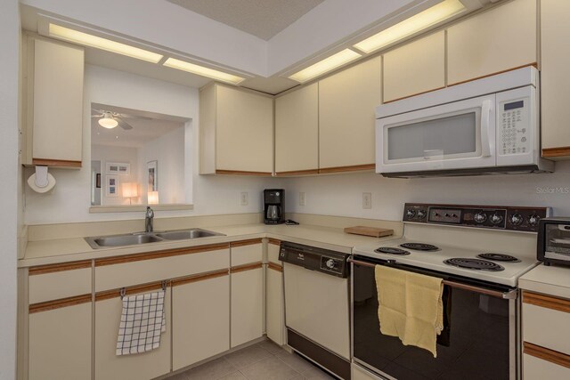 1241 S Martin Luther King Jr Ave Unit 302, Clearwater, FL 33756 - kitchen with white appliances, a sink, light countertops, and light tile patterned floors