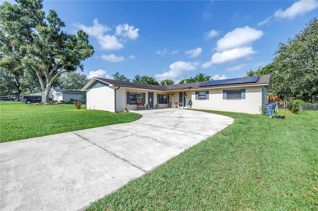 4821 S Gachet Blvd, Lakeland, FL 33813 - view of front facade with solar panels, a front lawn, and curved driveway