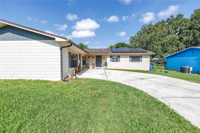 4821 S Gachet Blvd, Lakeland, FL 33813 - rear view of property featuring central AC unit, solar panels, and a yard