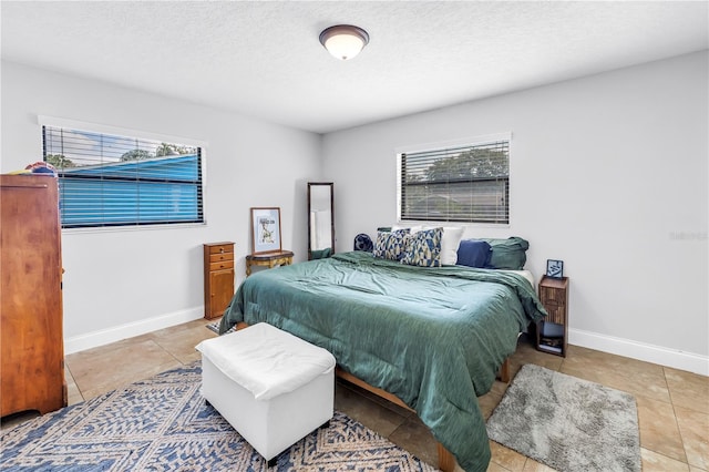 4821 S Gachet Blvd, Lakeland, FL 33813 - bedroom featuring light tile patterned floors, multiple windows, baseboards, and a textured ceiling