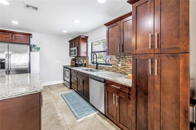 4821 S Gachet Blvd, Lakeland, FL 33813 - kitchen featuring appliances with stainless steel finishes, backsplash, light stone countertops, recessed lighting, and light tile patterned floors
