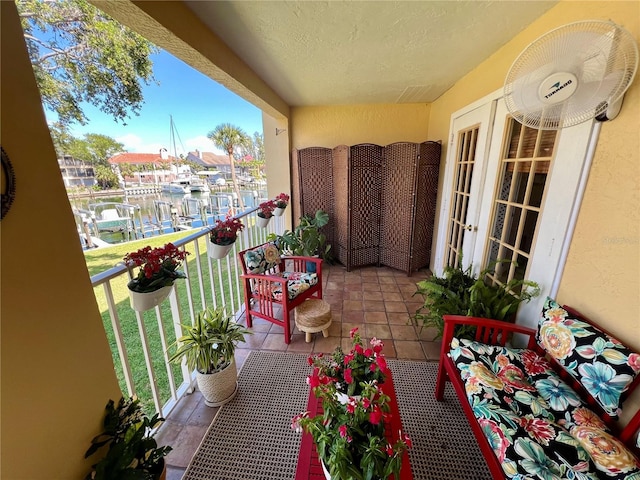 balcony featuring french doors and a water view