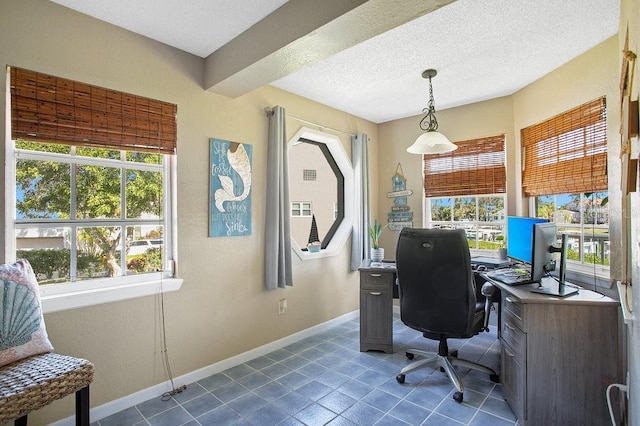 office with dark tile patterned flooring, baseboards, and a textured ceiling