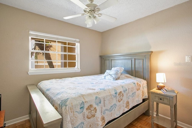 bedroom featuring baseboards, ceiling fan, and a textured ceiling