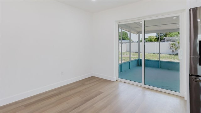 unfurnished room featuring light wood-type flooring and baseboards