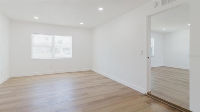 spare room with light wood-style flooring, recessed lighting, and baseboards